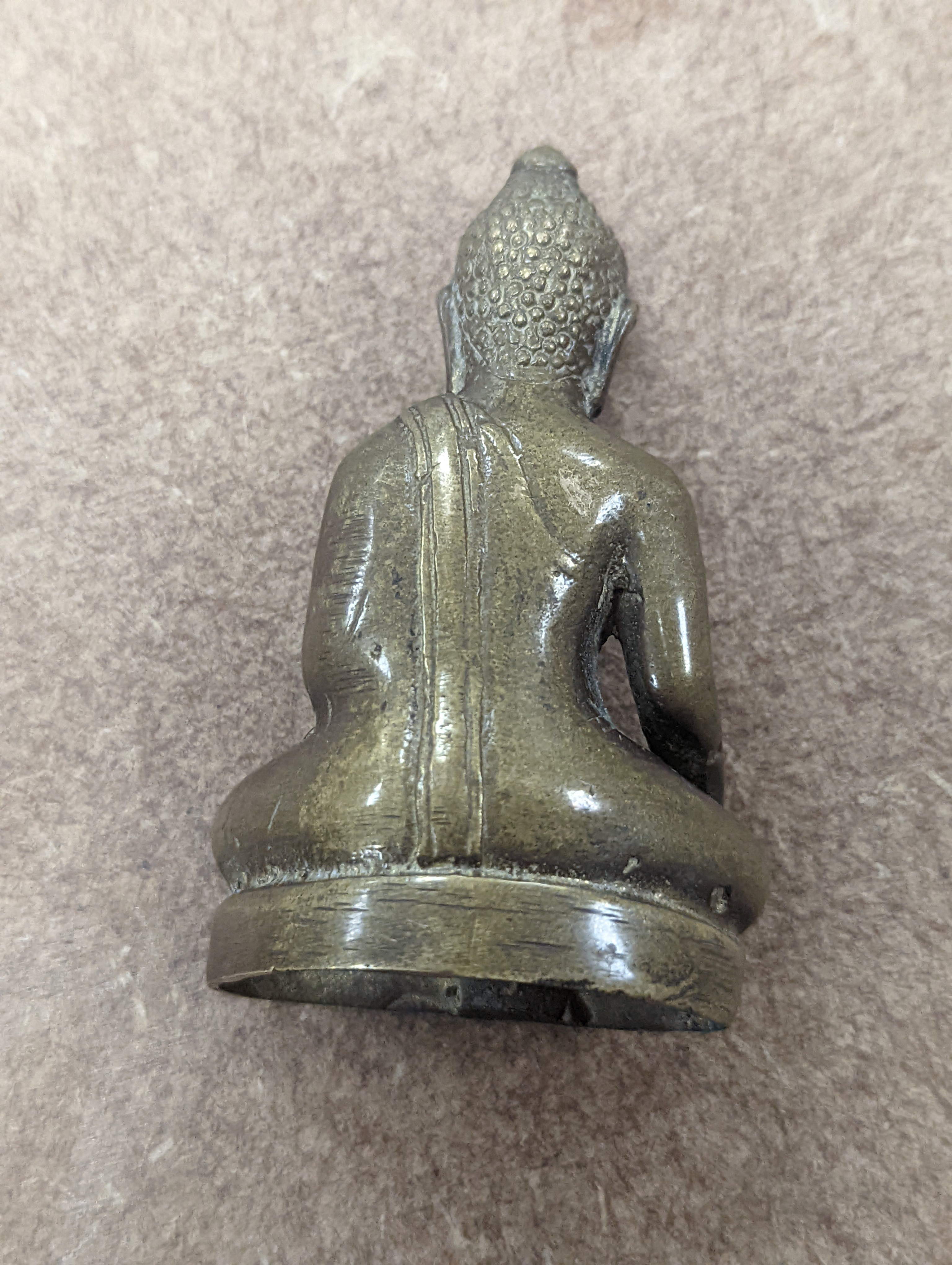 A bronze hand warmer with Xuande mark, 10 cm wide and two Himalayan Buddhist figures, tallest 6.8 cm (3)